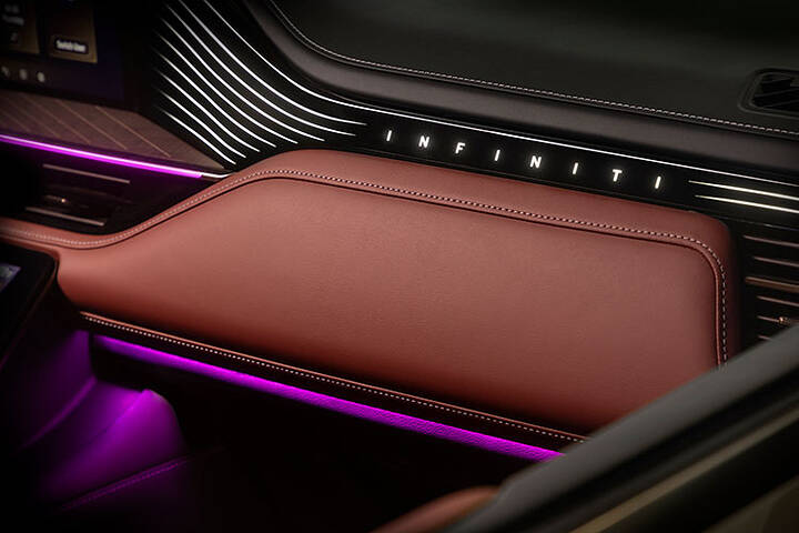 Interior of a door with the lit-up INFINITI nameplate on the 2025 INFINIT QX80.